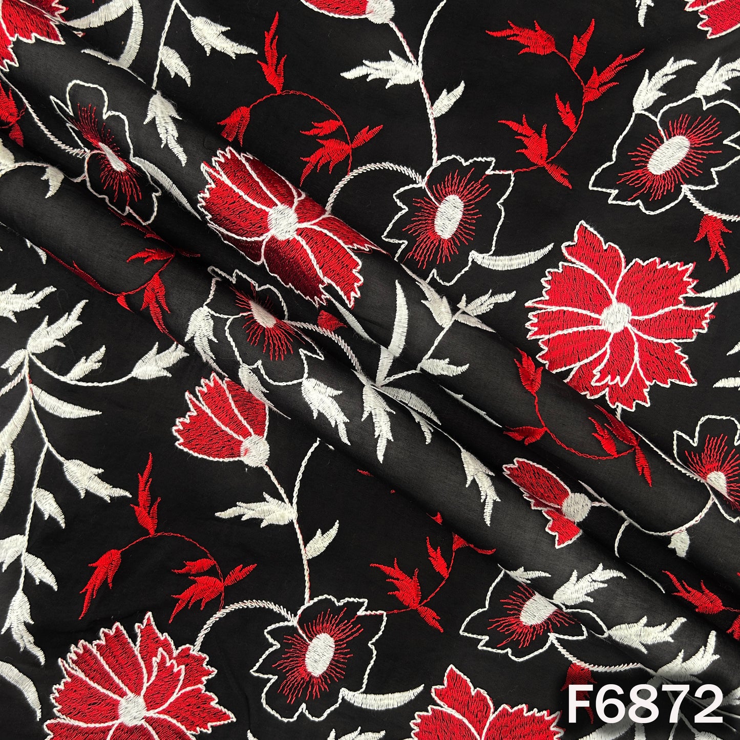 Close-up of black 2x2 Rubia cotton fabric F6872 showing red and white floral thread embroidery