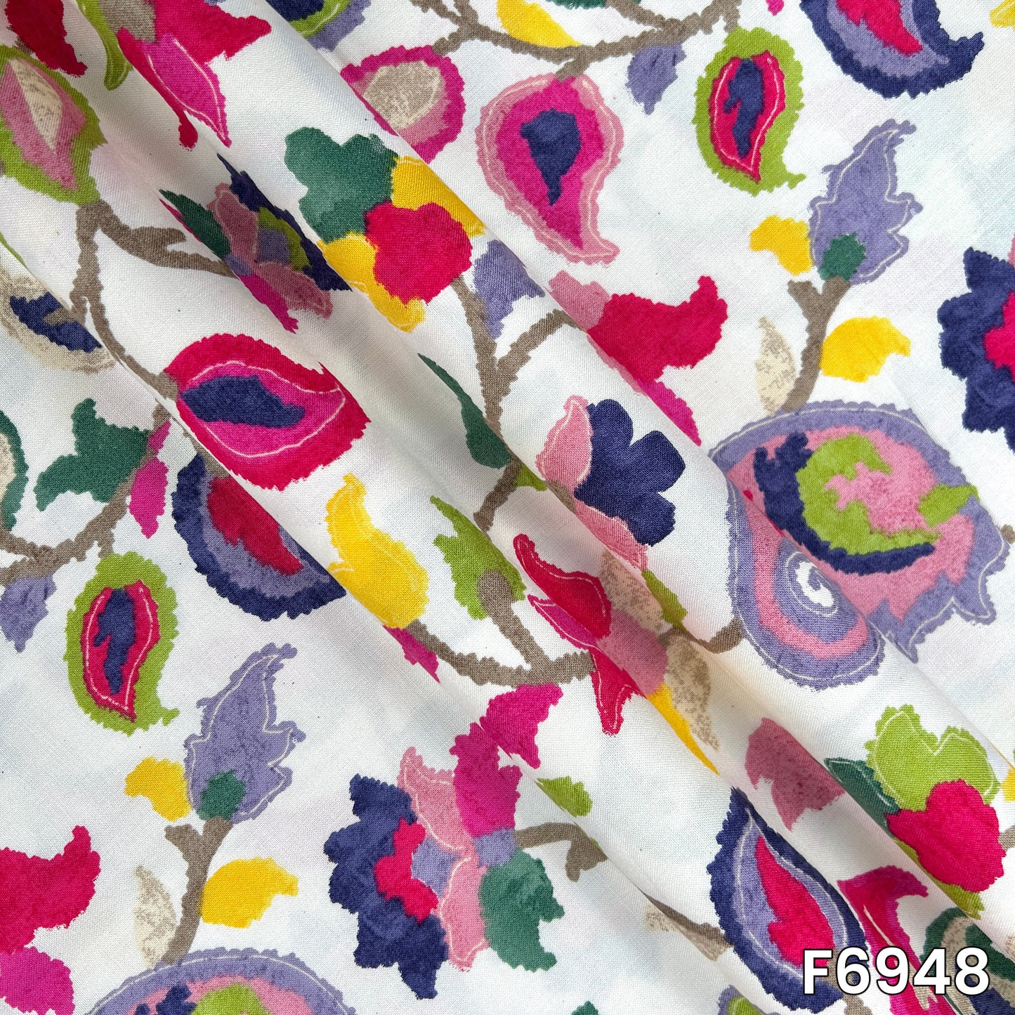 Folded rayon material showing fluid drape, smooth texture and richly colored botanical artwork