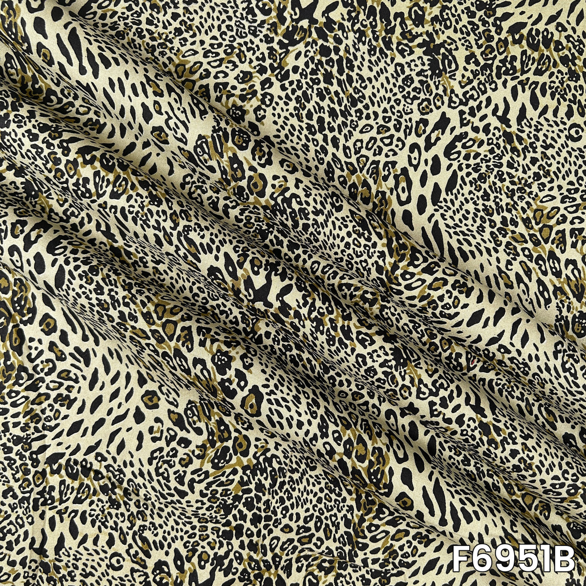 Magnified olive F6951B fabric image highlighting irregular spots, fluid folds and lightweight texture