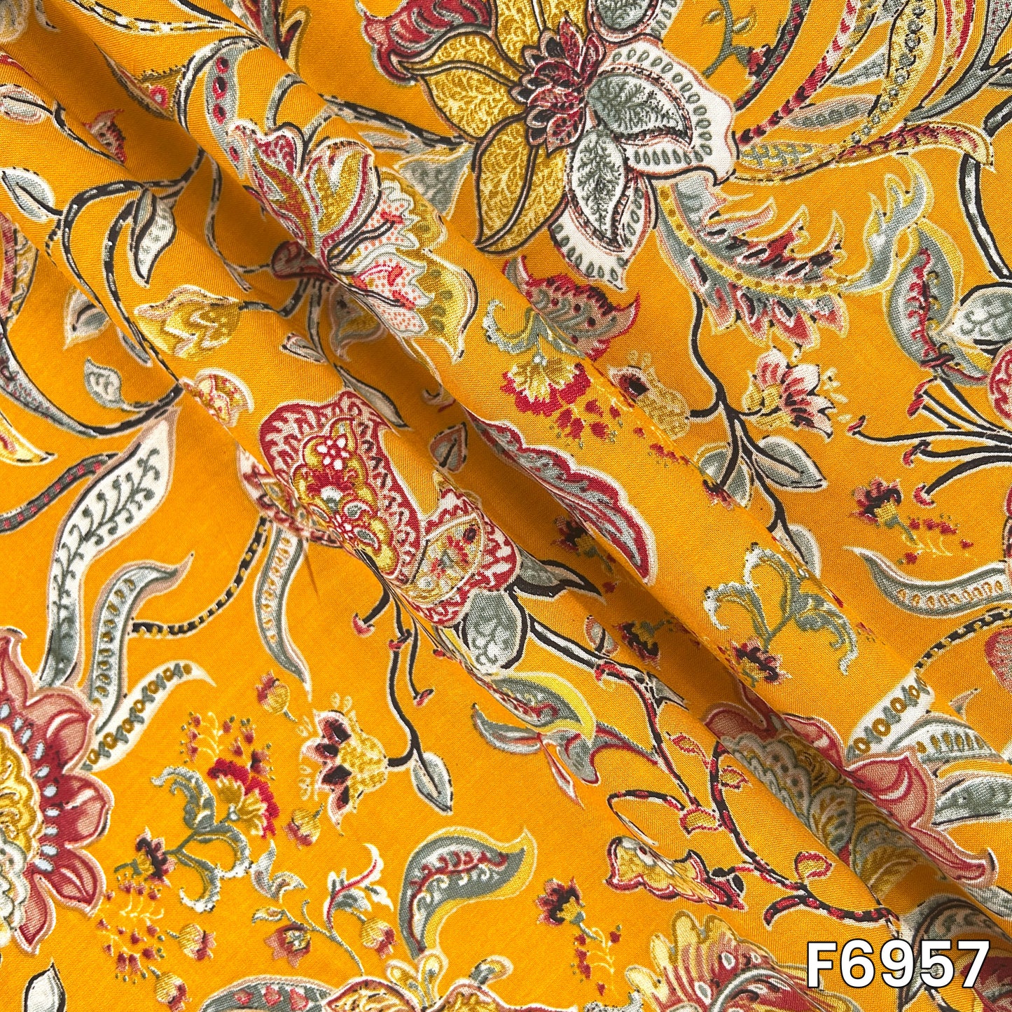Folded rayon material F6957 showing smooth drape, lightweight texture and clearly defined ethnic motifs
