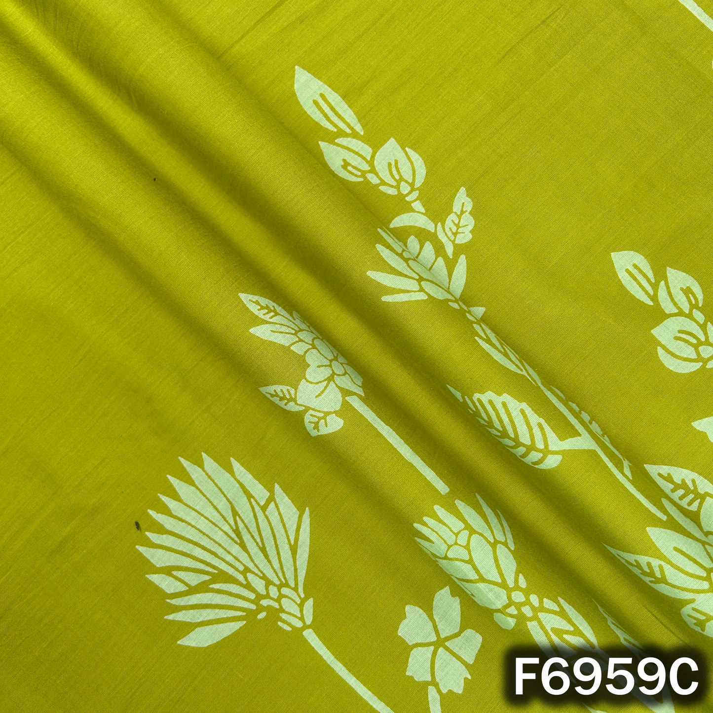 Close-up of F6959C displaying leafy flower shapes, bright green base and soft cotton drape