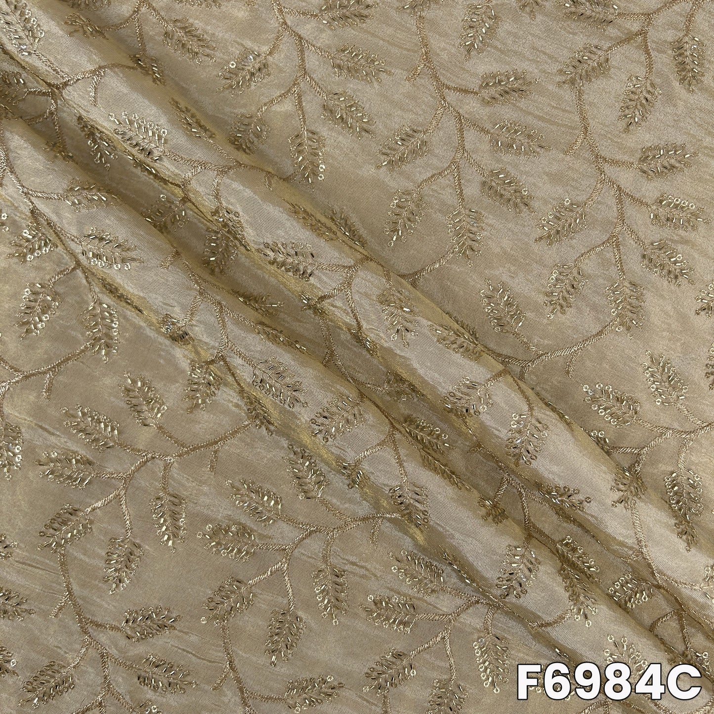 Detailed F6984C surface showing pale metallic sheen, floral embroidery and refined occasion-wear finish