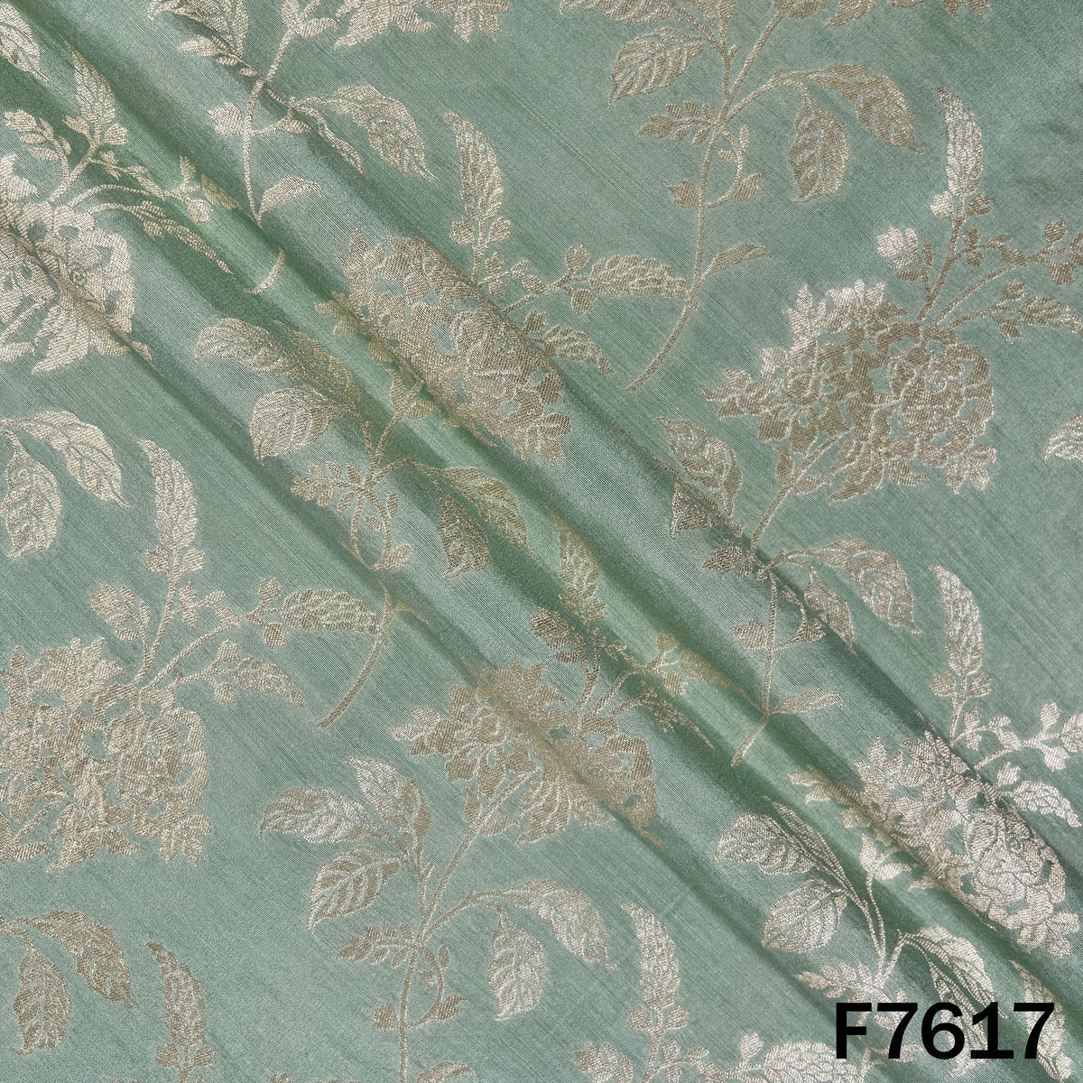 Draped mint green Monga silk fabric with golden zari weaving