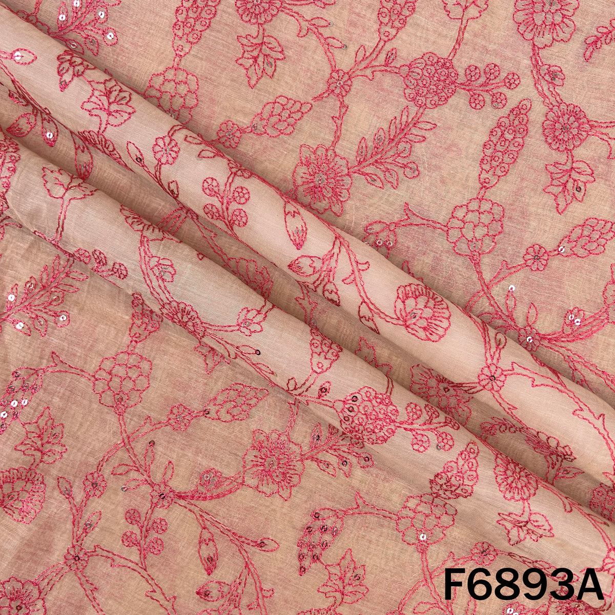 Close view of pink F6893A Chanderi fabric showing elegant floral embroidery on a soft base