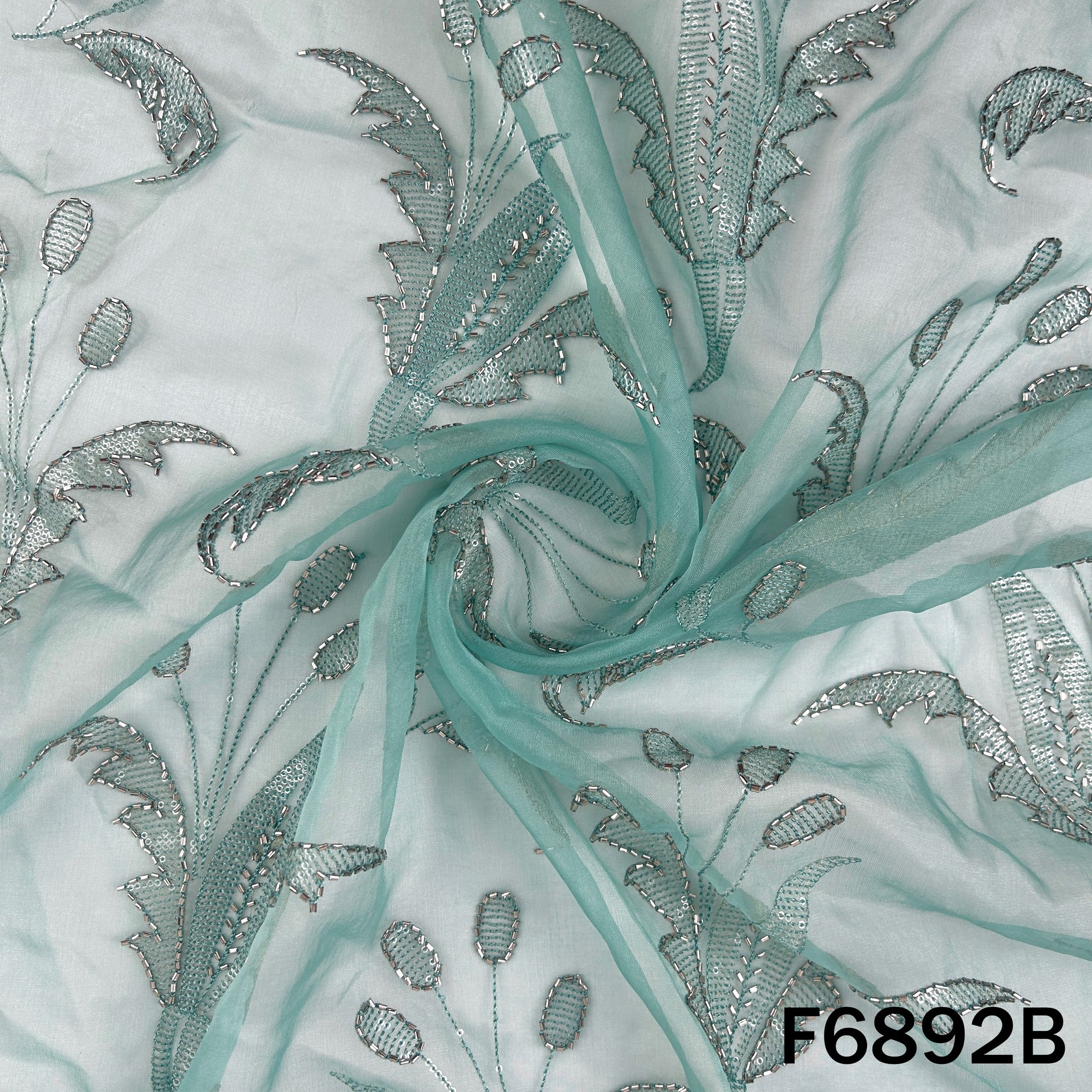 Close view of aqua embroidered organza fabric F6892B highlighting its festive cut dana texture