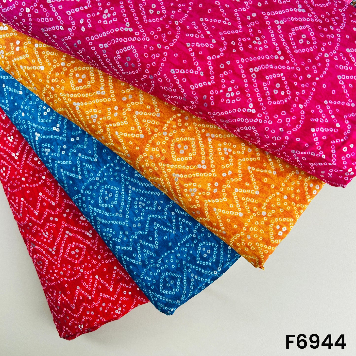 Multicolor foil print rayon fabric F6944 presented in red, teal, orange and magenta Bandhani-inspired patterns