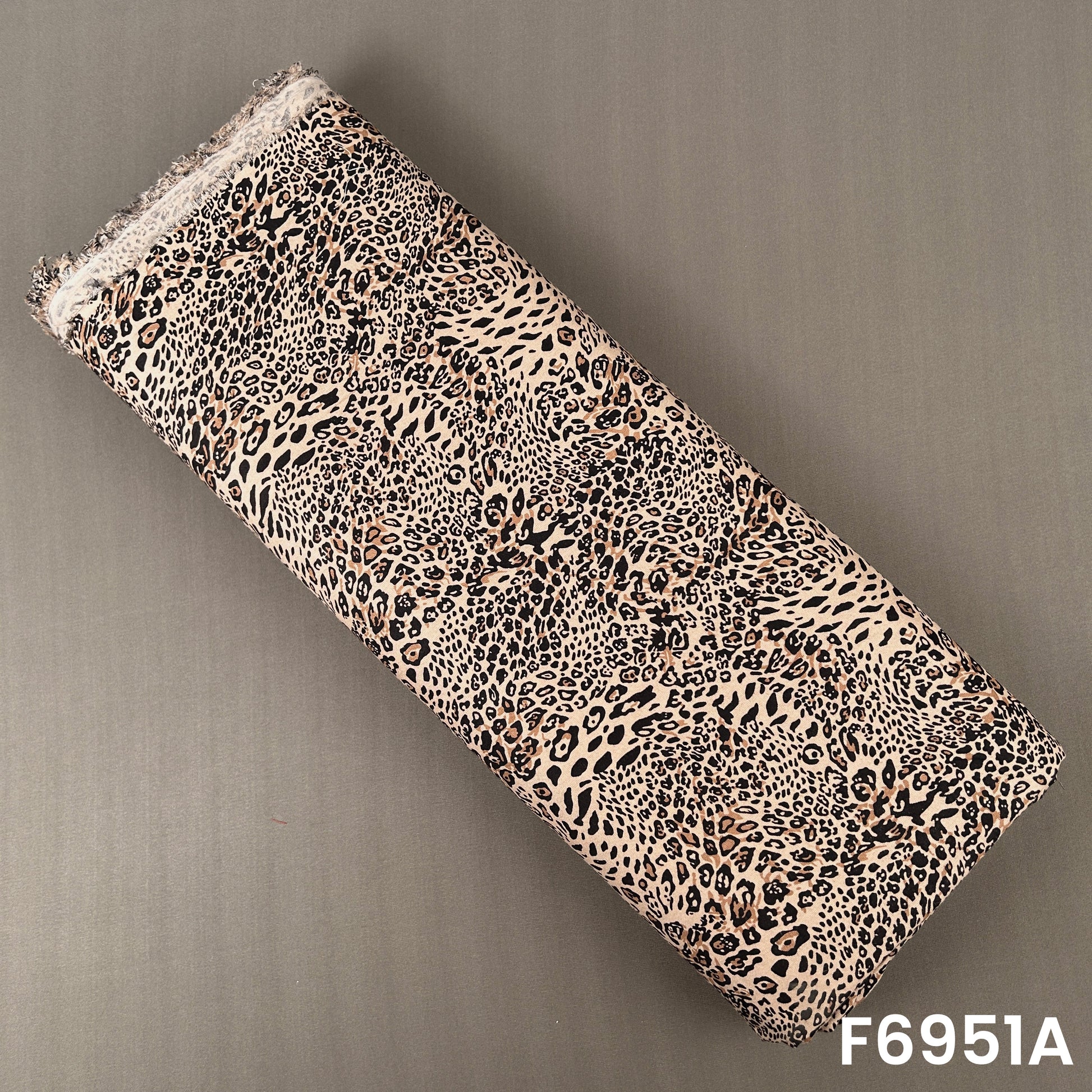 Beige and brown rayon fabric F6951A featuring dense leopard spots for bold contemporary clothing