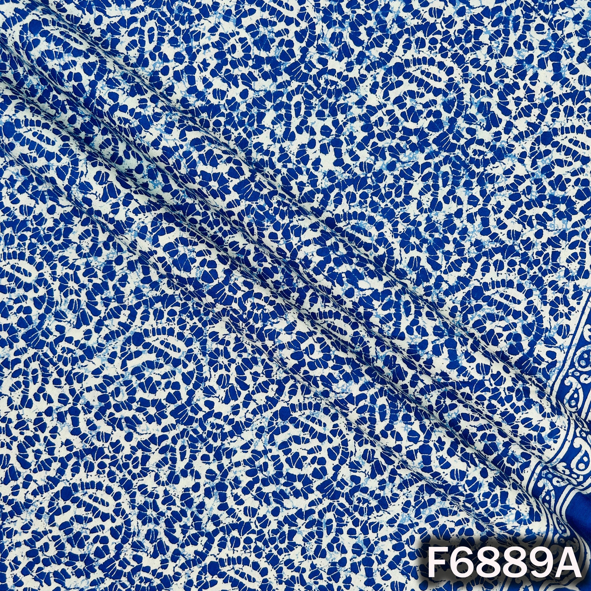 Close-up of F6889A blue cotton fabric showing detailed white lace-inspired printed texture
