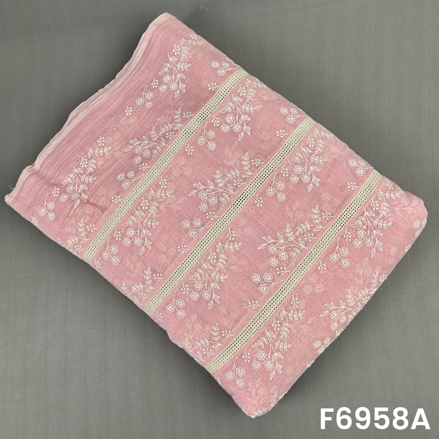 Blush pink Mul Chanderi fabric F6958A decorated with white flower motifs and refined lace-style stripe detailing