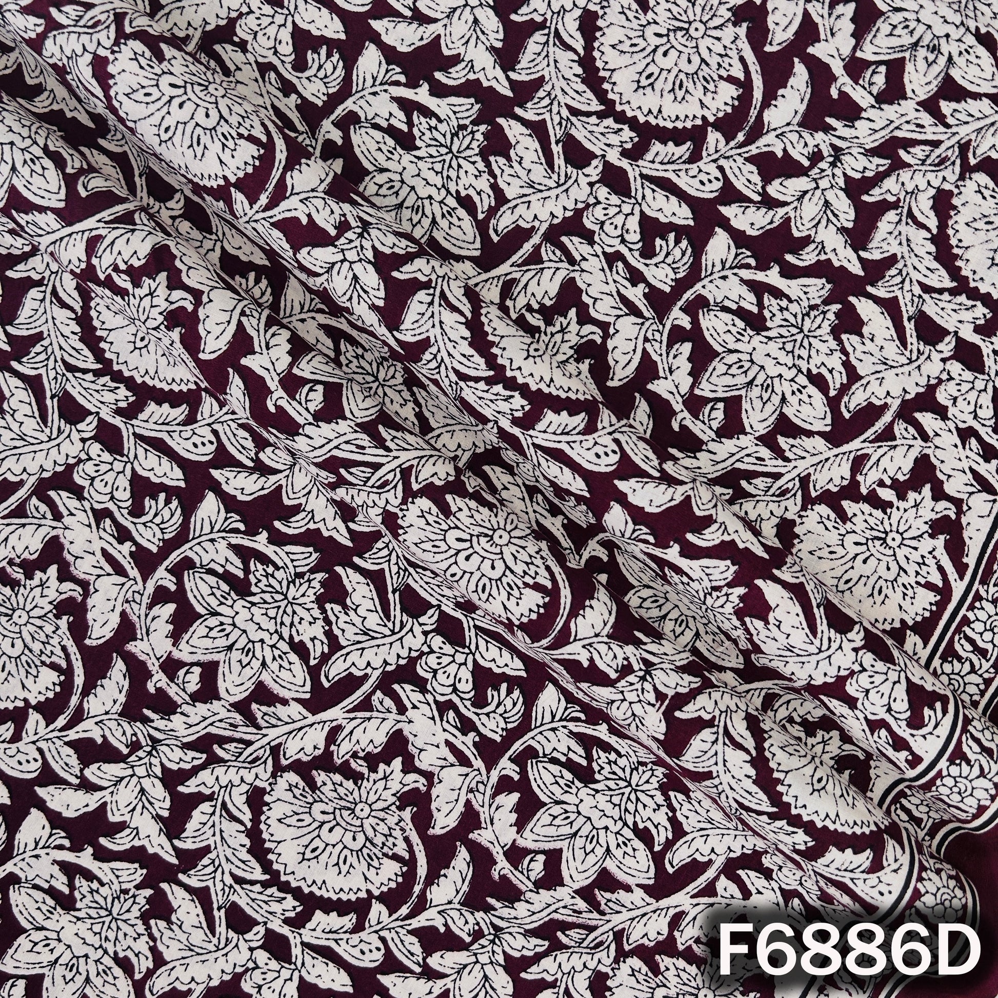 Close view of F6886D wine cotton fabric displaying fine floral detailing and premium printed texture