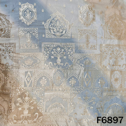 Close-up of F6897 shimmer tissue fabric showing silver zari motifs with soft blue ombre shading