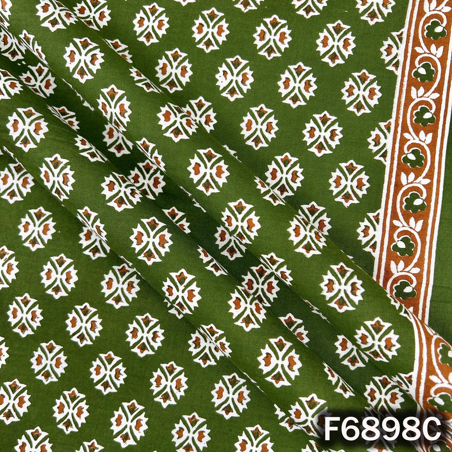 Close view of F6898C green cotton fabric displaying clean motif placement and smooth cotton texture