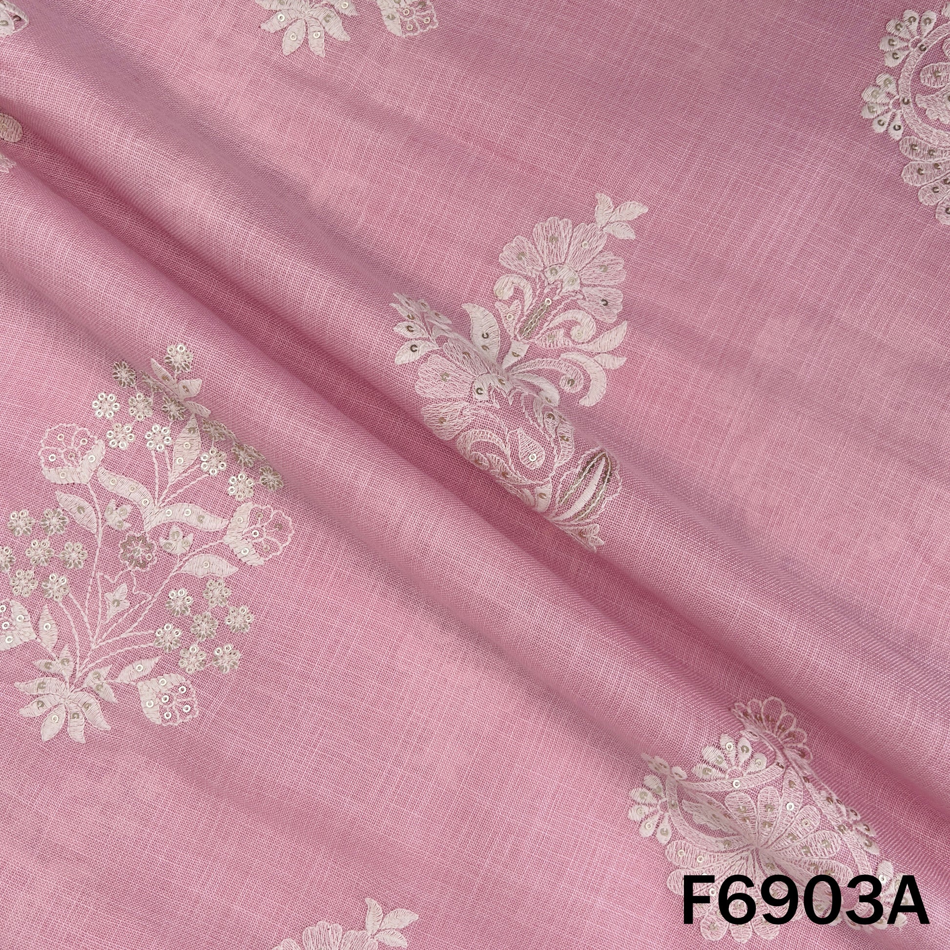 Close view of F6903A revealing graceful embroidered motifs across a lightly textured linen base