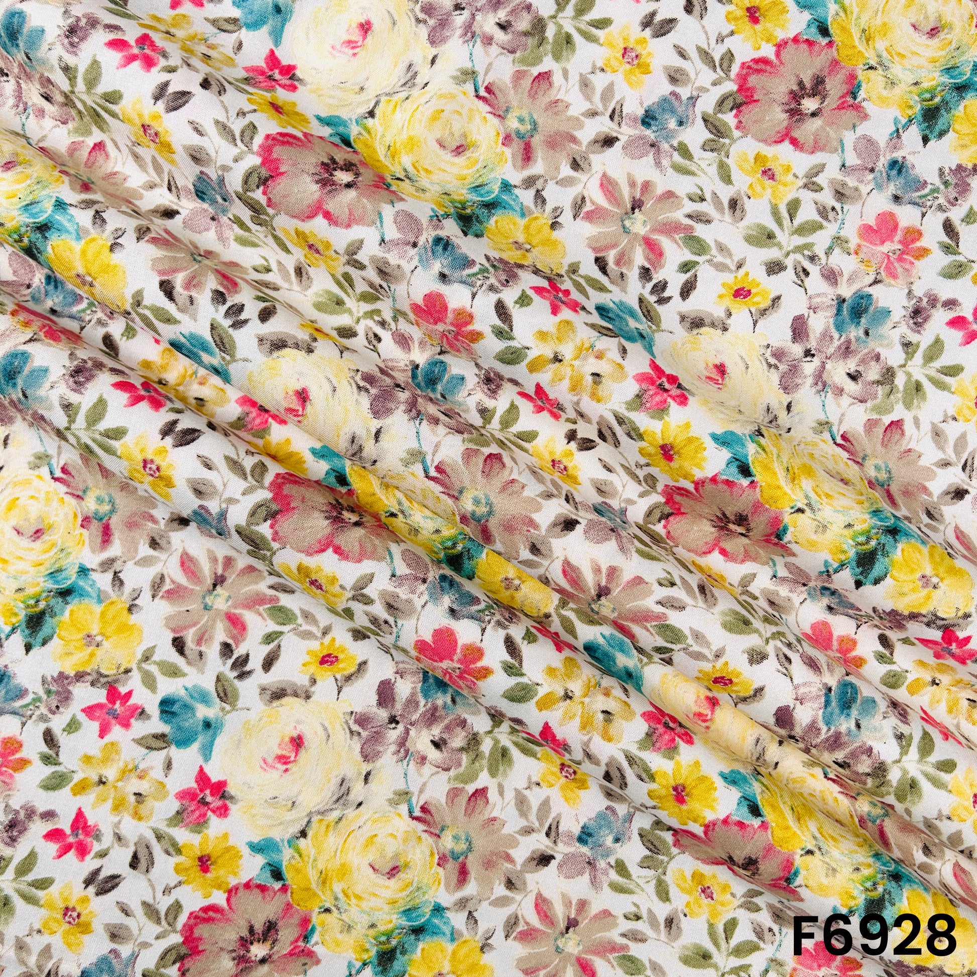 Draped F6928 rayon fabric displaying smooth folds, lightweight flow and delicate multicolor floral artwork