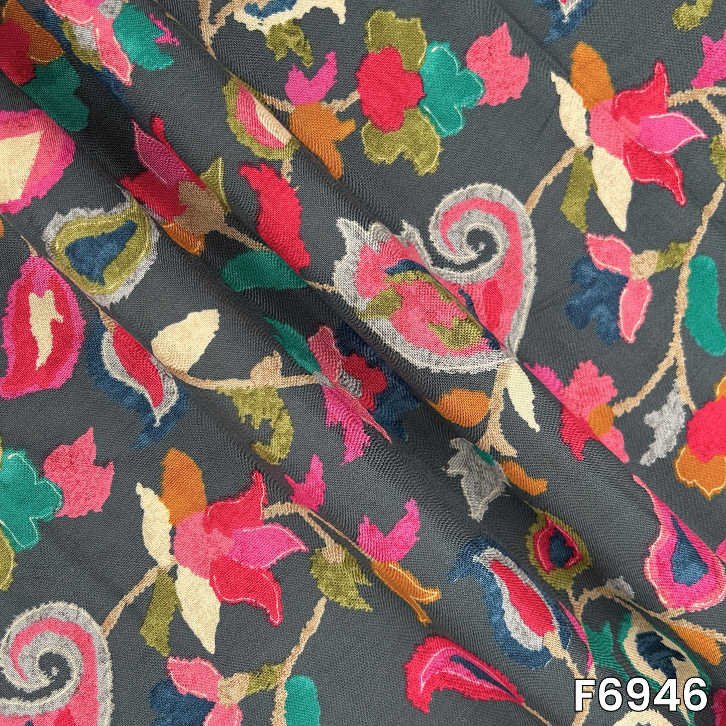 Draped rayon fabric F6946 displaying its fluid fall, smooth surface and richly layered botanical artwork