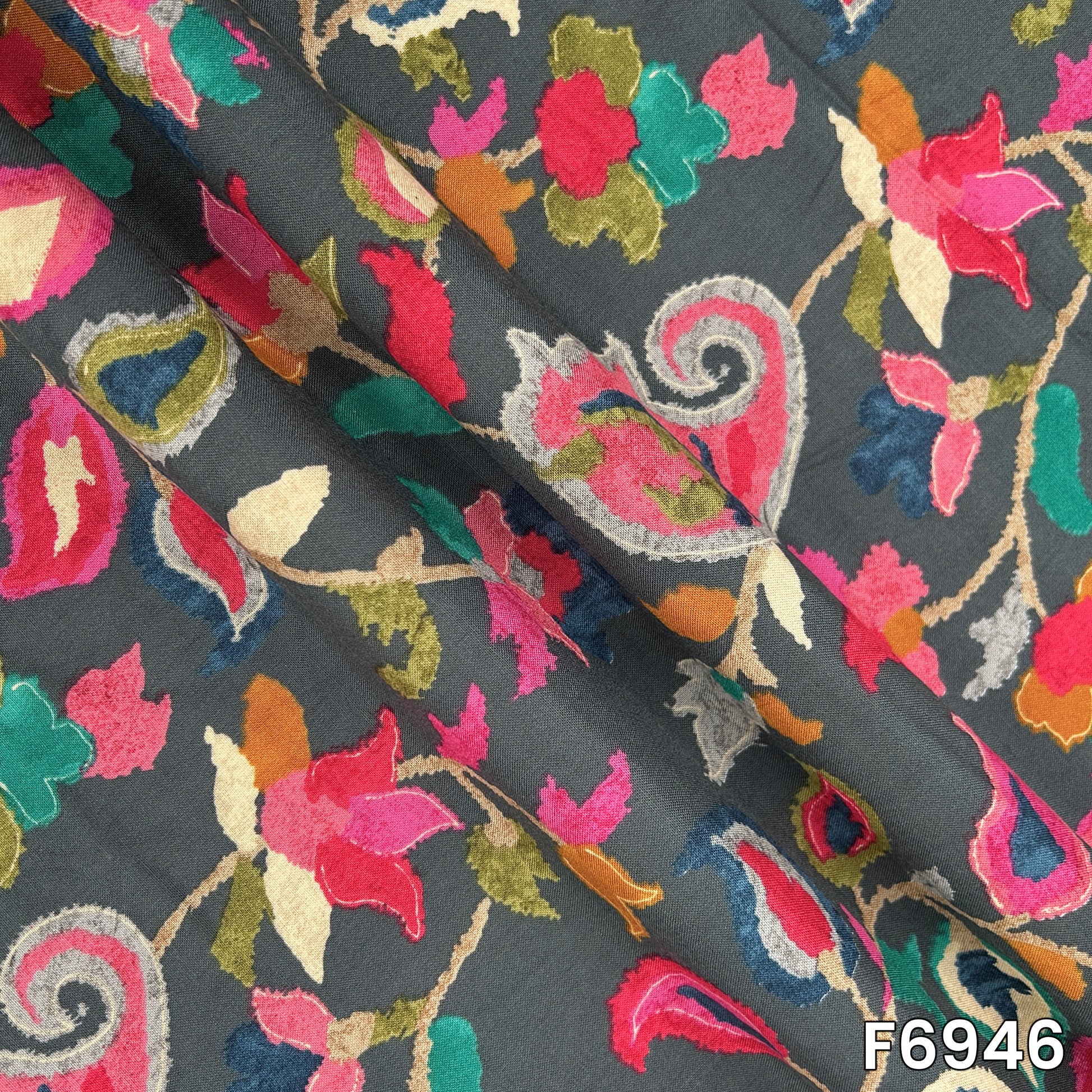 Draped rayon fabric F6946 displaying its fluid fall, smooth surface and richly layered botanical artwork