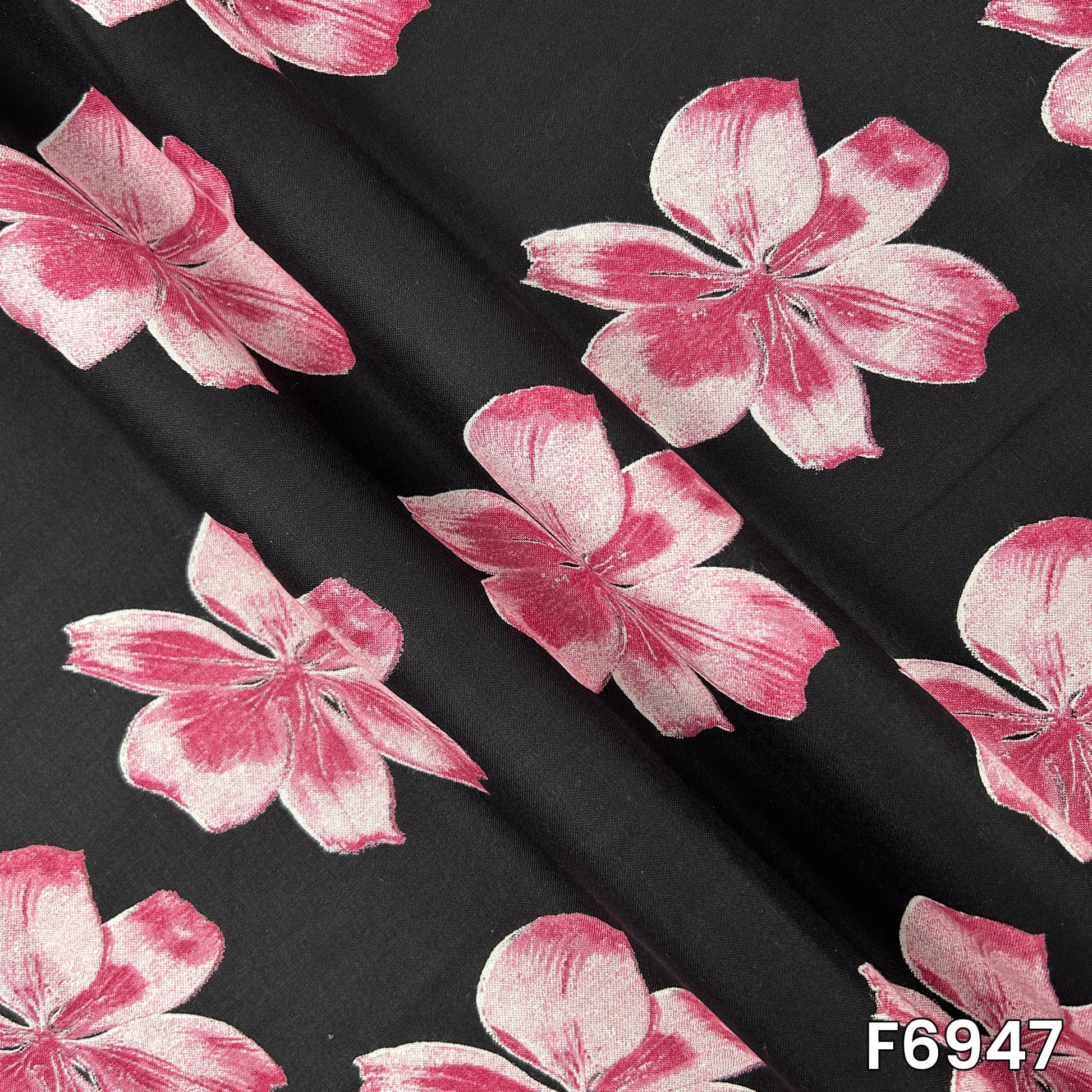 Draped rayon material F6947 revealing fluid folds, lightweight texture and clearly defined flower motifs
