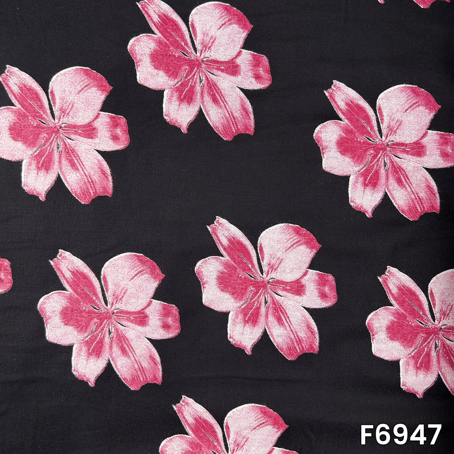 Full pattern view of F6947 showing soft pink blossoms with shaded petals against a classic black background
