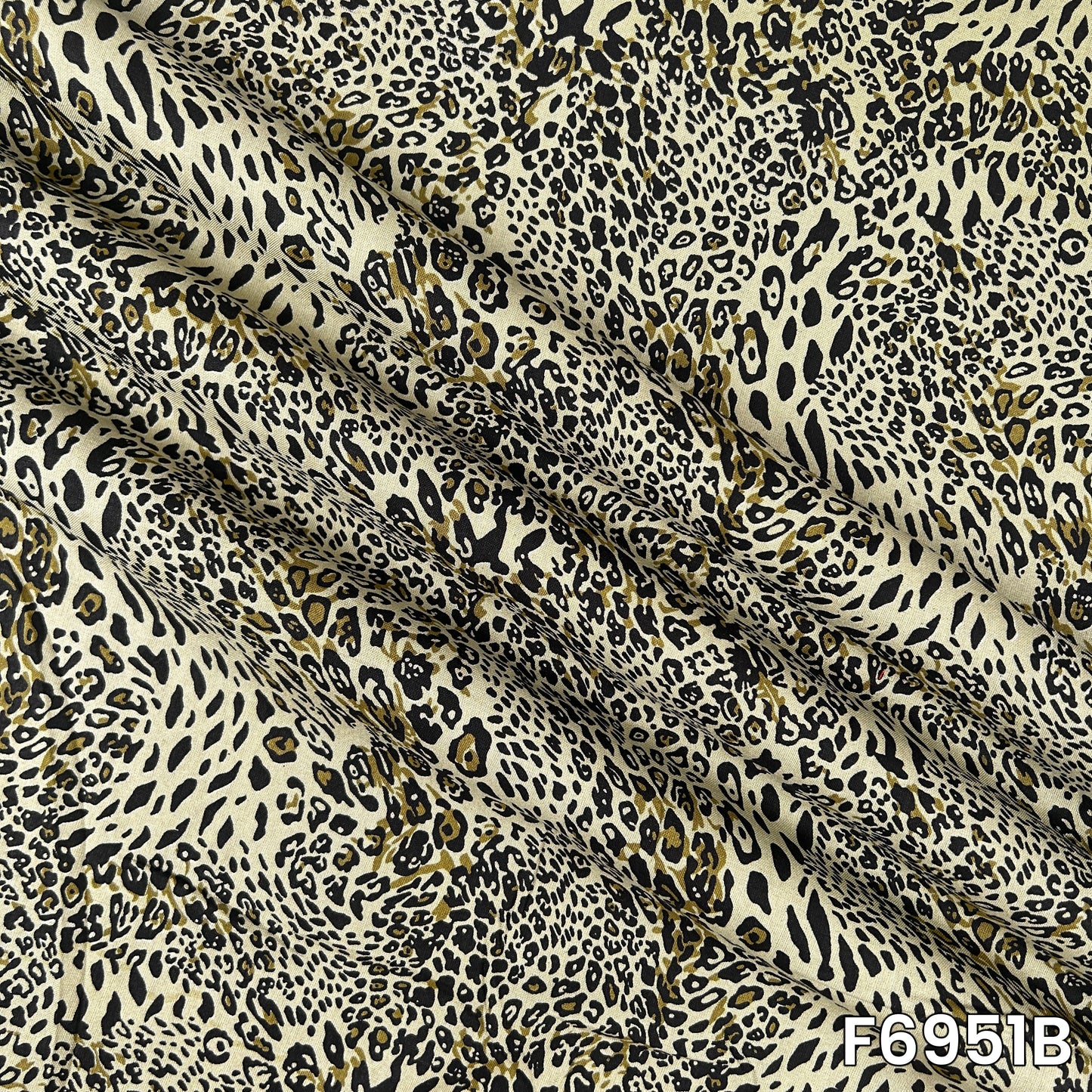 Magnified olive F6951B fabric image highlighting irregular spots, fluid folds and lightweight texture