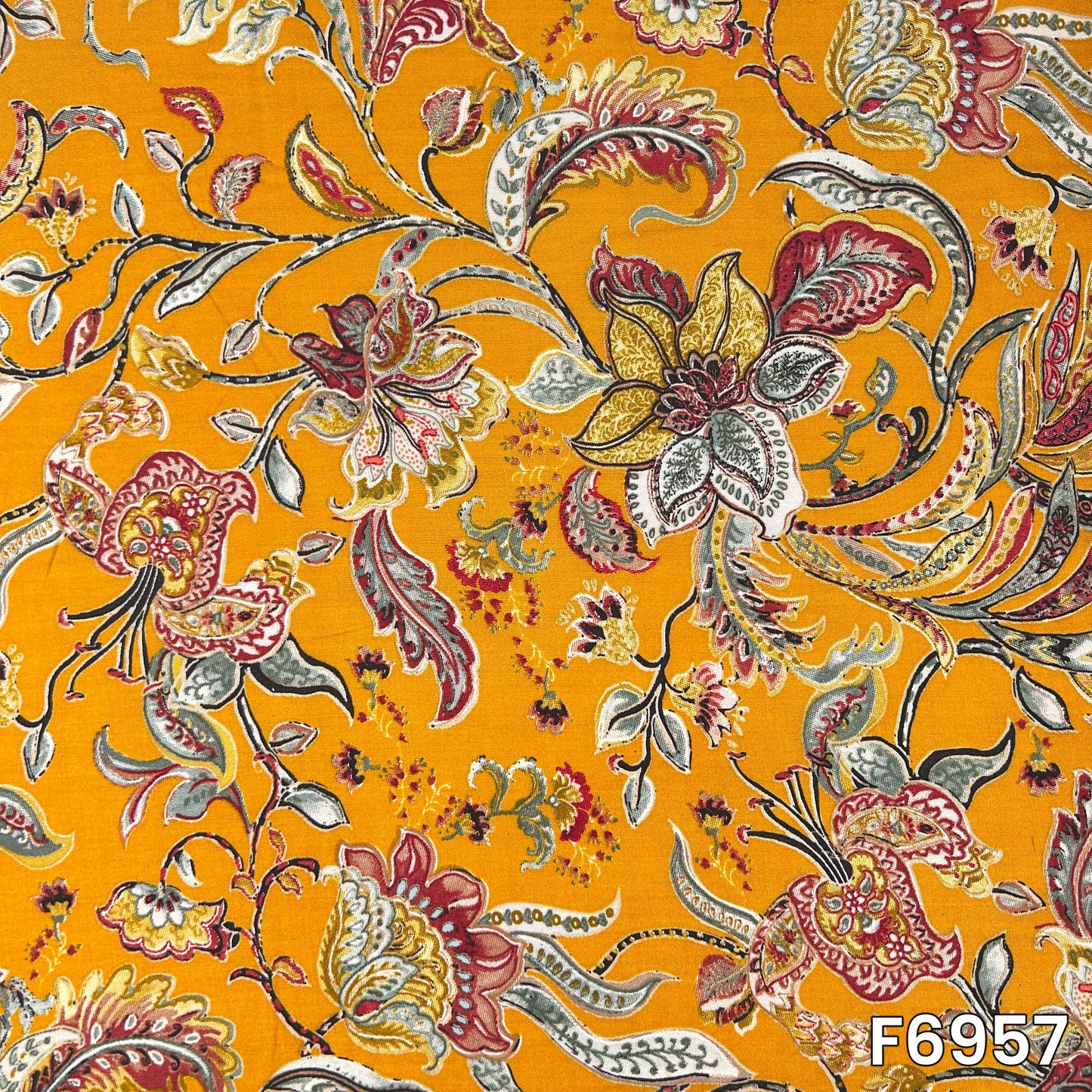Full pattern view of F6957 revealing curved paisleys, fine leaves and ornamental flowers across the bright base