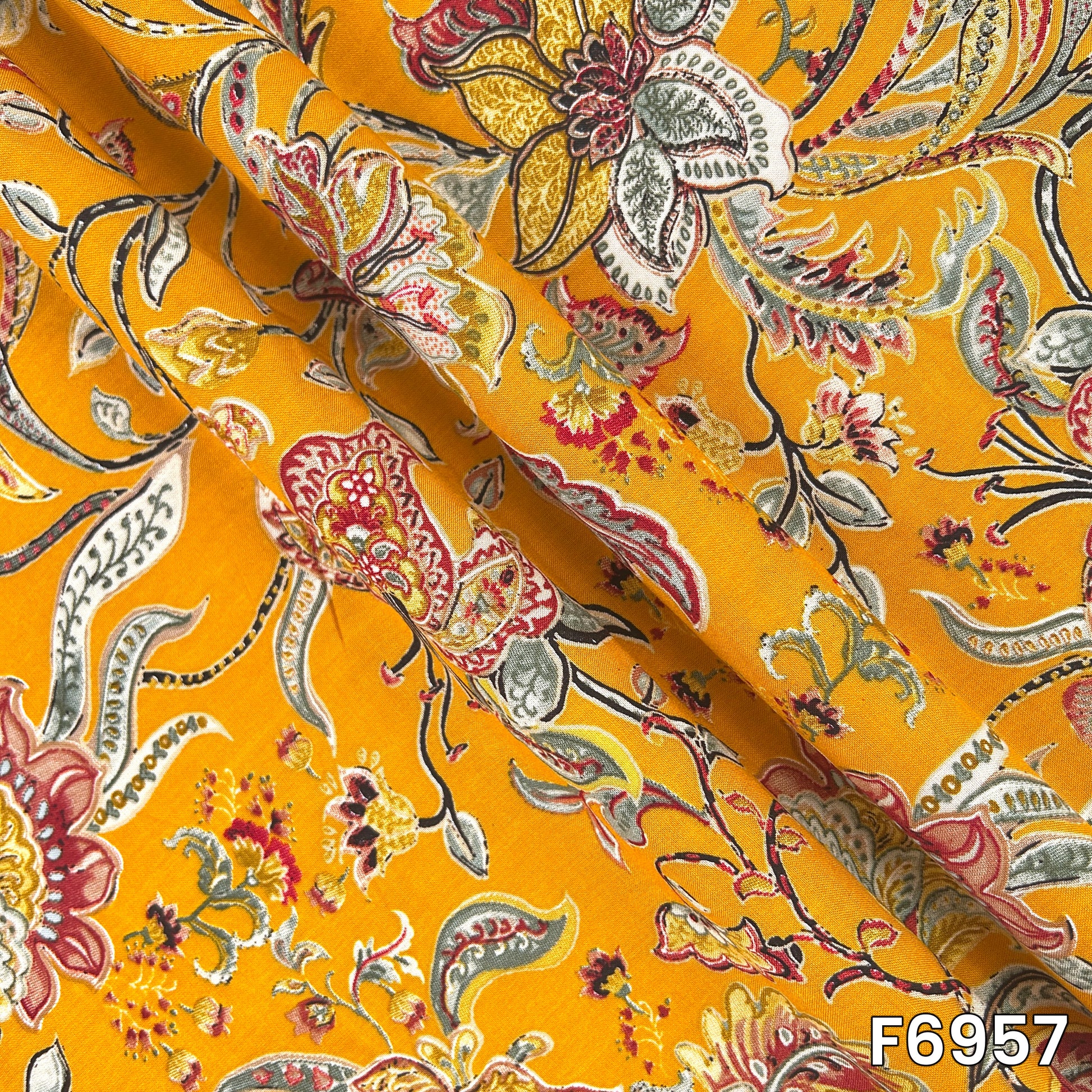 Folded rayon material F6957 showing smooth drape, lightweight texture and clearly defined ethnic motifs
