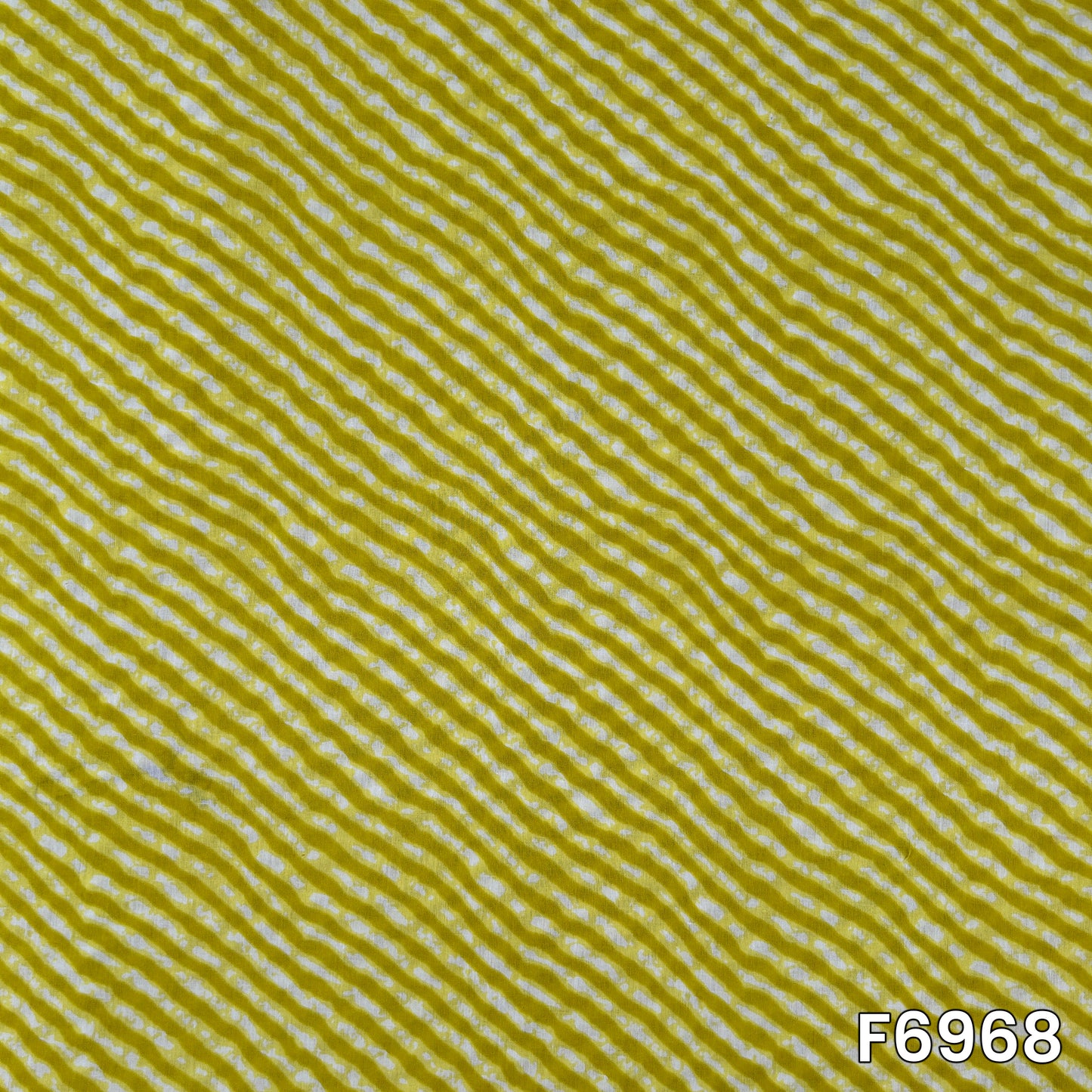 Close pattern view of F6968 showing fine white wavy lines across a bright mustard cotton base