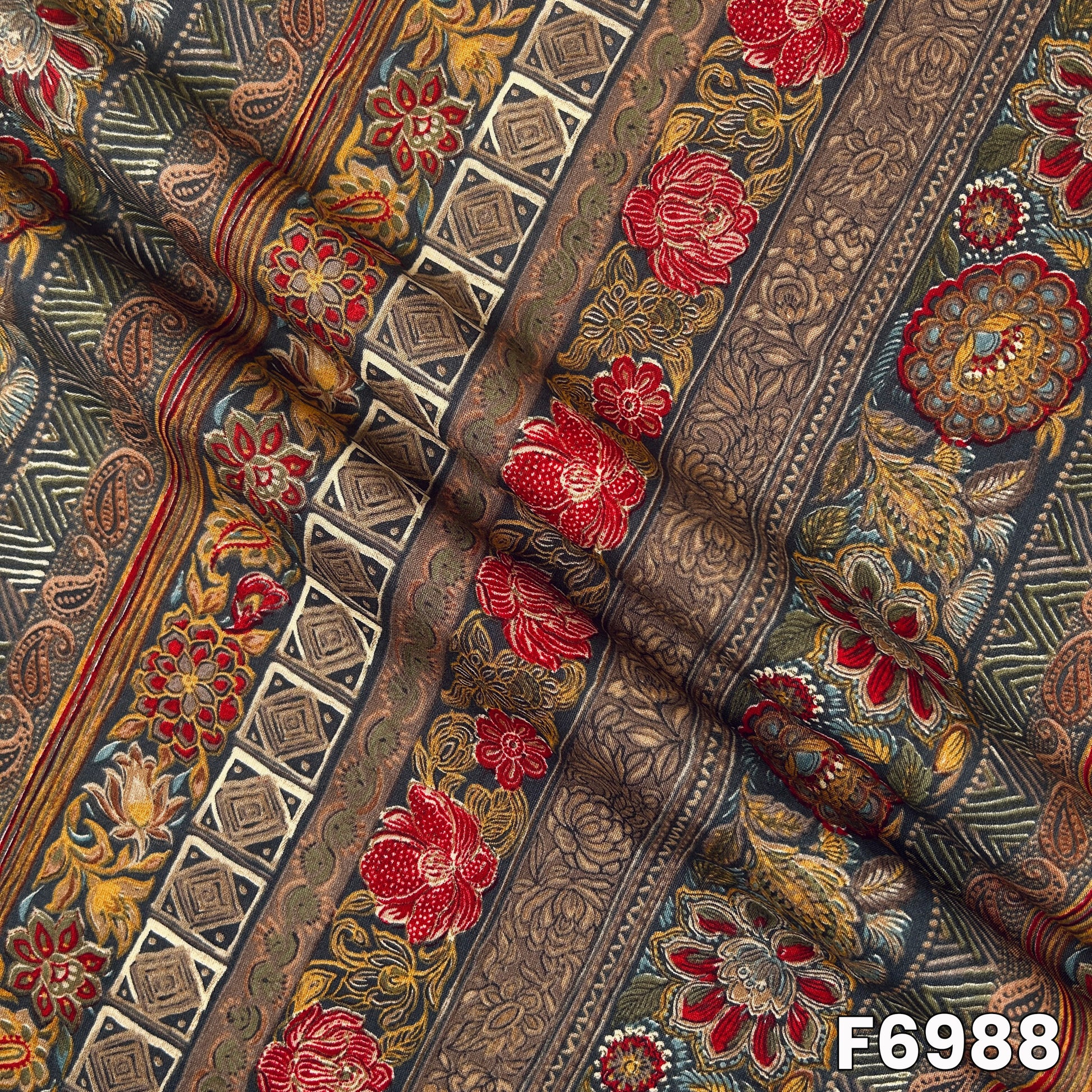 Draped F6988 rayon fabric highlighting smooth fall, rich earthy tones and detailed ornamental print placement