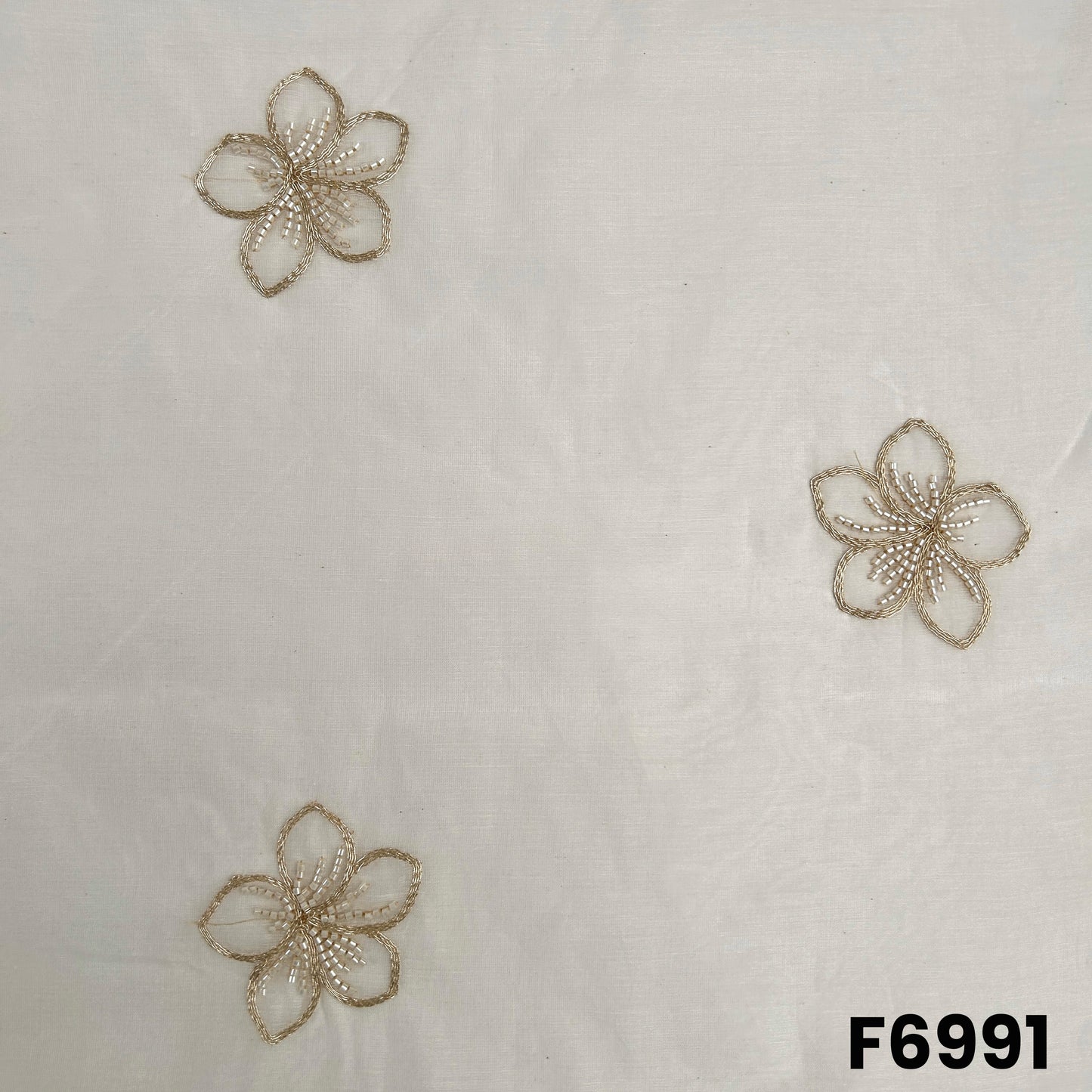 Close pattern view of F6991 highlighting floral butti design, fine zari outlines and subtle cut dana texture