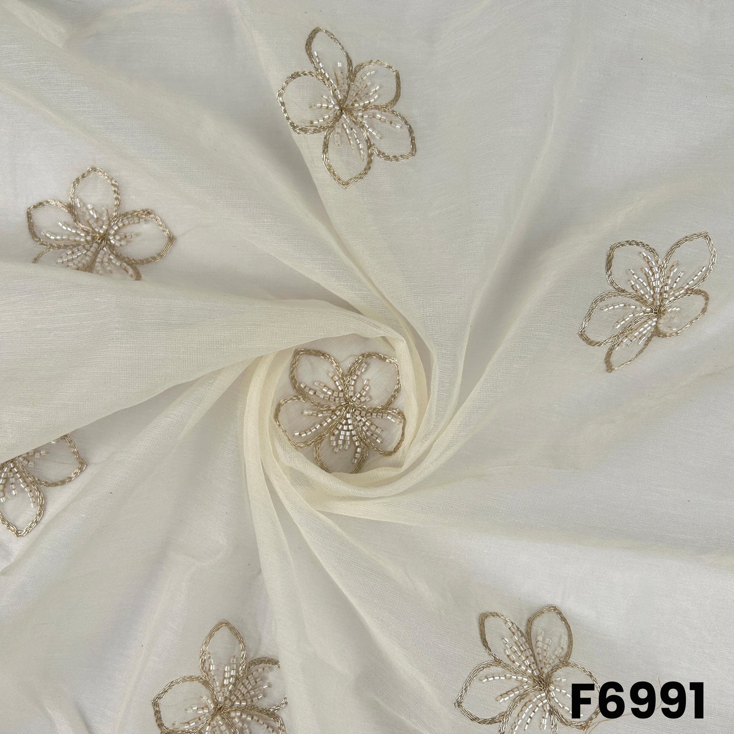 Draped F6991 Chanderi Silk fabric showing soft sheen, airy folds and delicate metallic floral embroidery