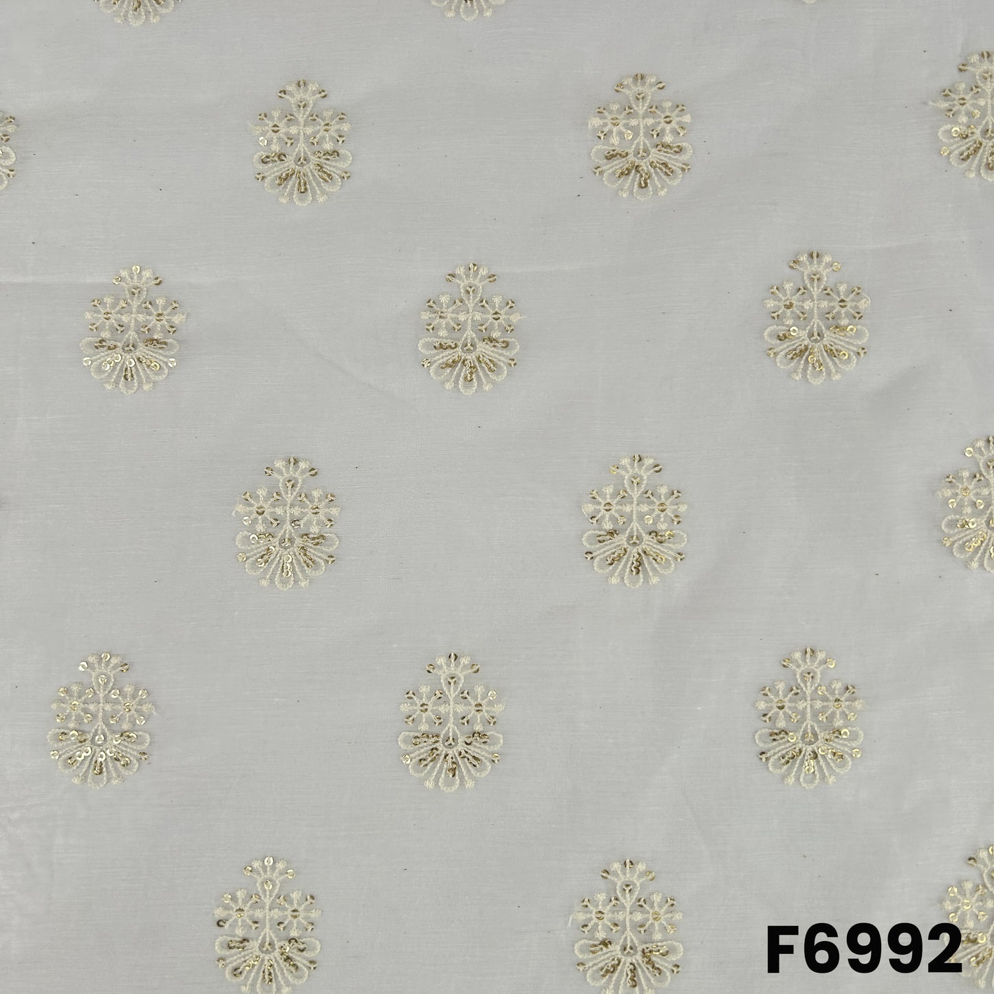 Close pattern view of F6992 highlighting golden floral butti motifs across a lightweight dyeable silk base