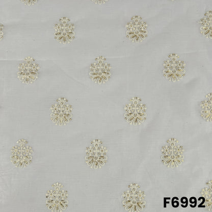 Close pattern view of F6992 highlighting golden floral butti motifs across a lightweight dyeable silk base