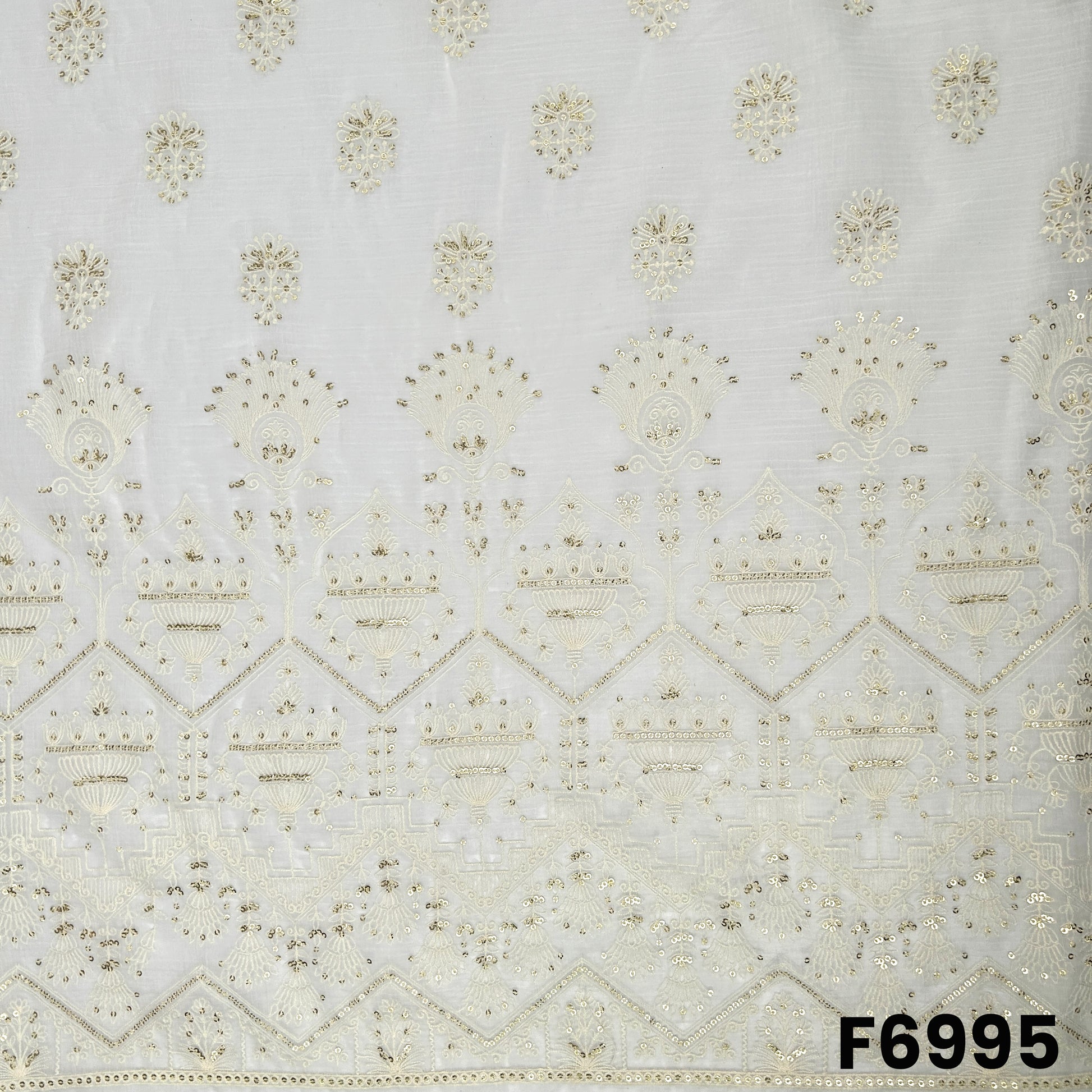 Close view of F6995 showing grand border embroidery, fine threadwork and shimmering sequins on an off-white base