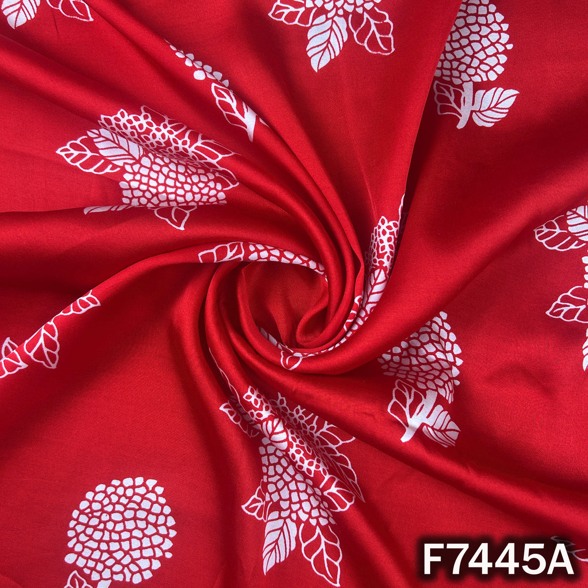 Red printed modal satin fabric with white floral motifs