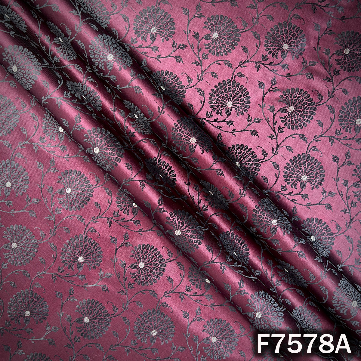 Draped wine brocade fabric with subtle zari motifs