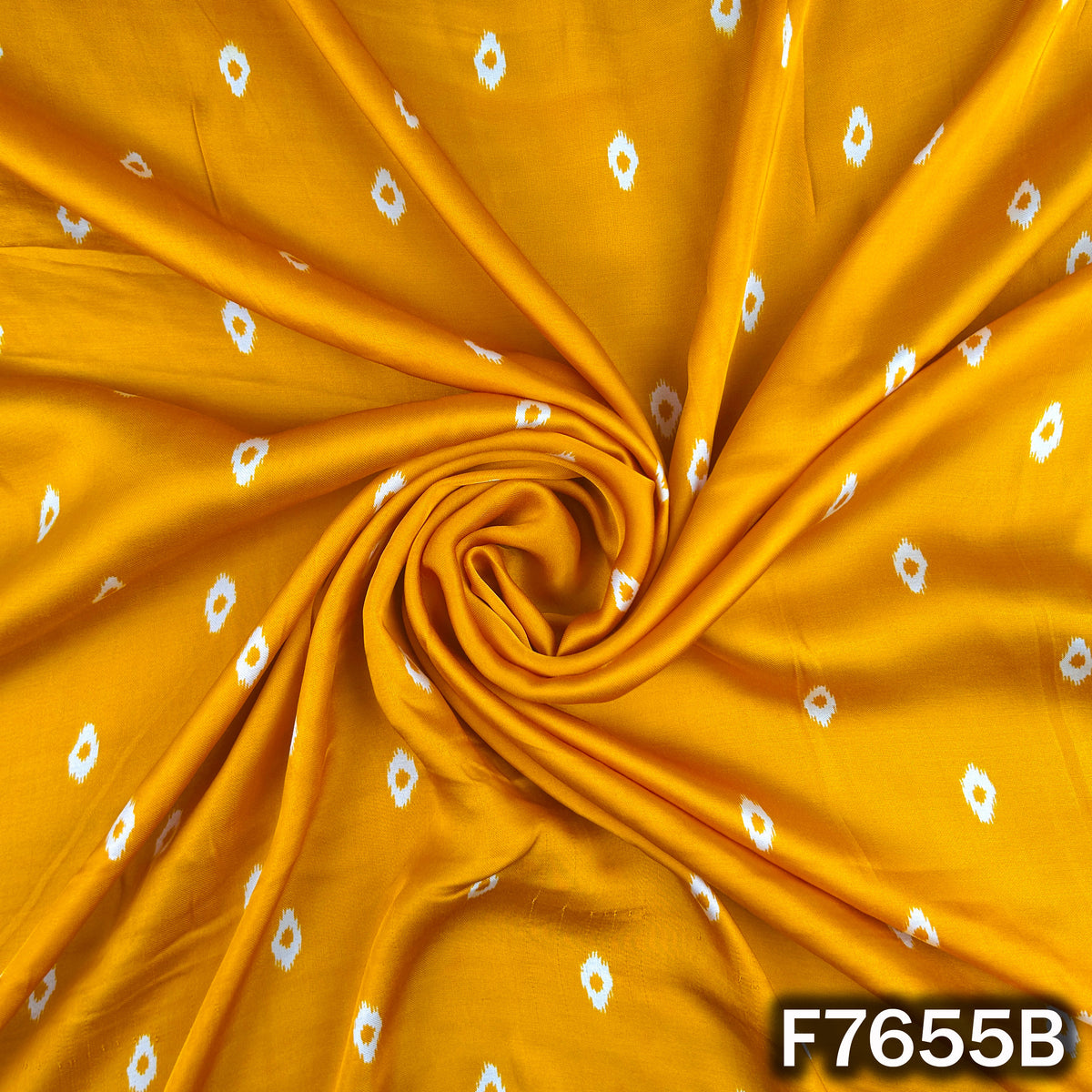 Draped mustard yellow modal satin fabric with white dotted print