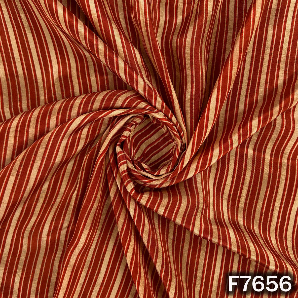 Draped rust orange crepe fabric with elegant vertical stripes