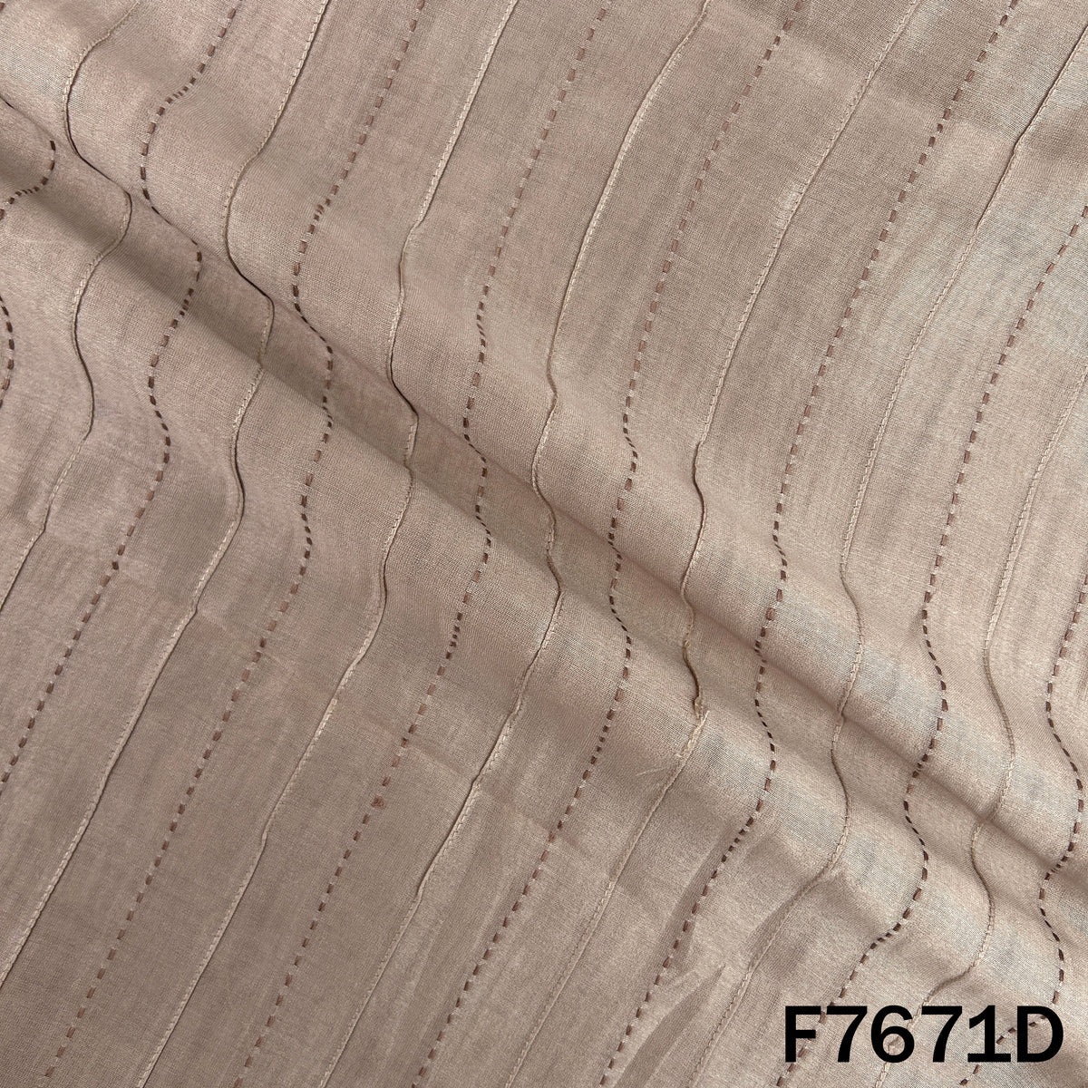 Draped beige Monga silk with fine linear embroidery