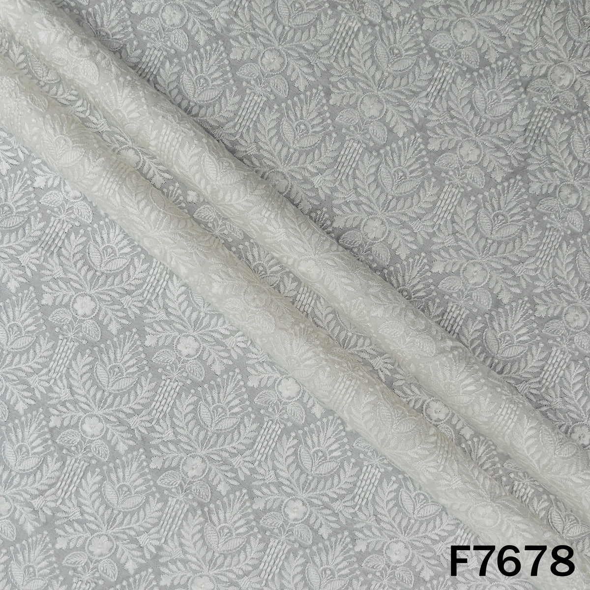 Draped ivory raw silk fabric with delicate floral embroidery