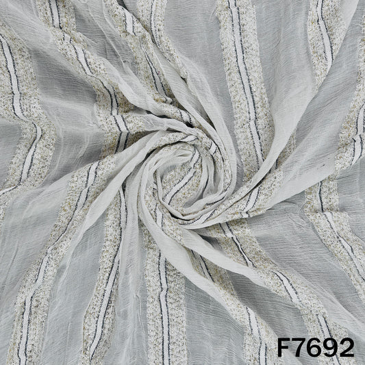 Draped white georgette fabric with shimmering zari stripes
