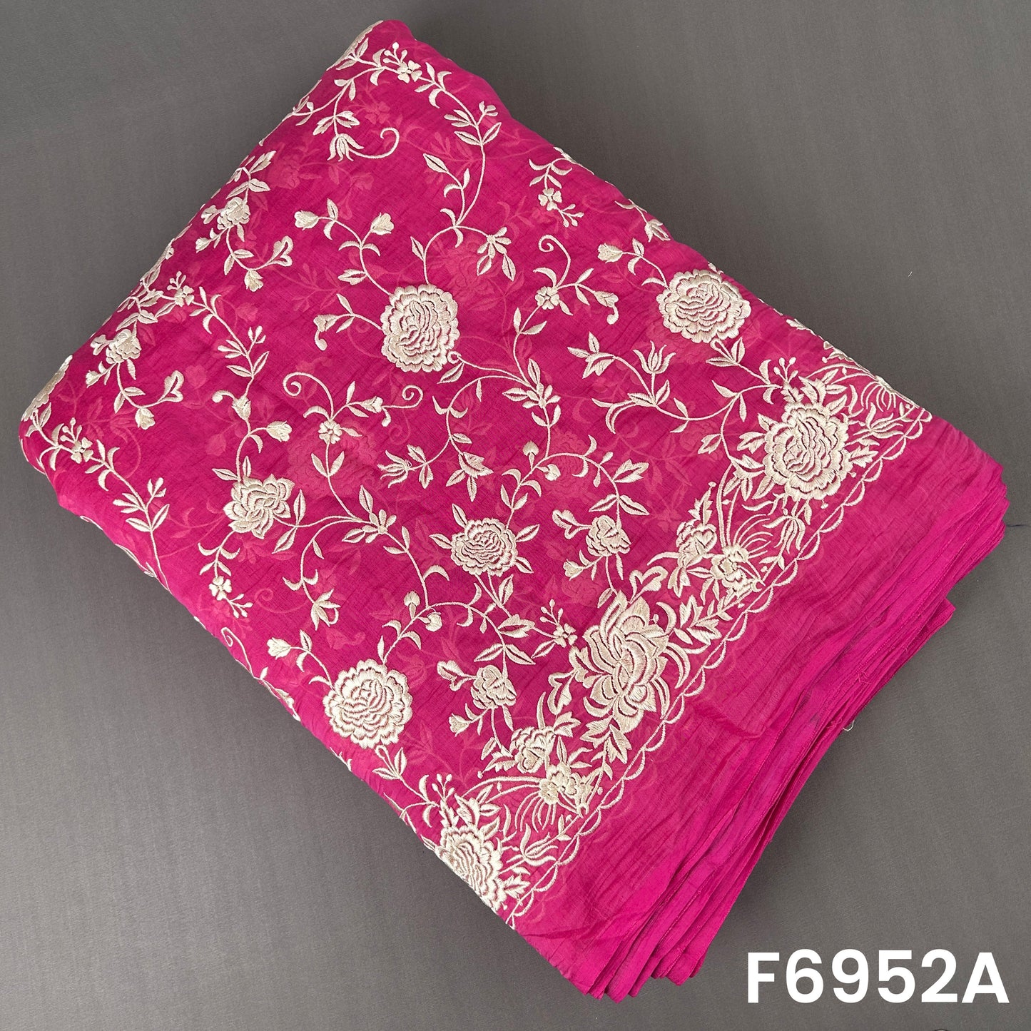 Fuchsia Mul Chanderi fabric F6952A adorned with detailed cream flowers and flowing leafy branches