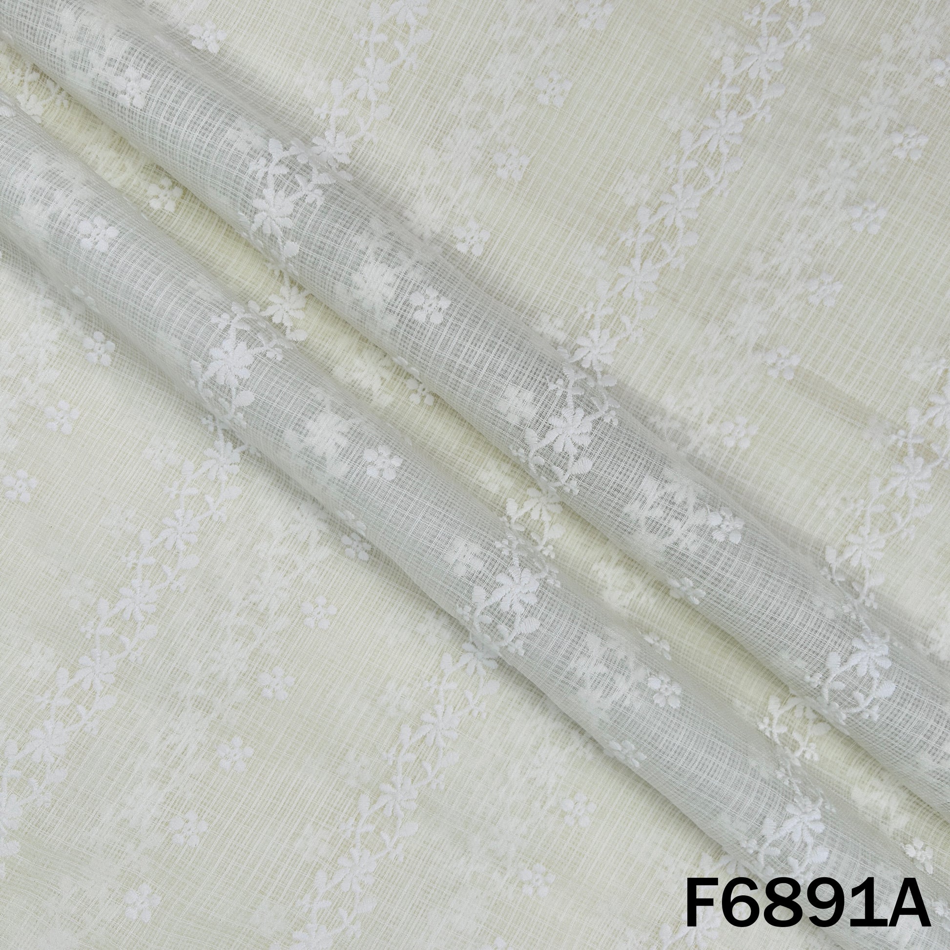 Close-up of F6891A Kota cotton fabric showing fine white embroidery on a soft ivory base