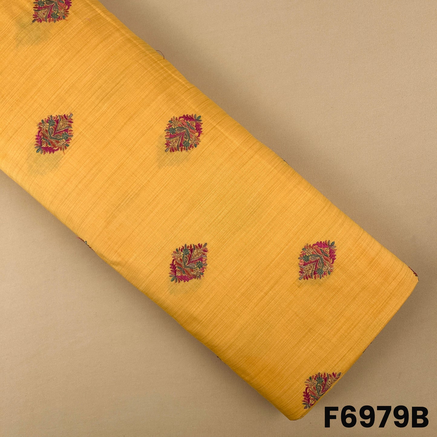 Mustard yellow semi silk fabric F6979B decorated with colorful paisley motifs for festive outfits