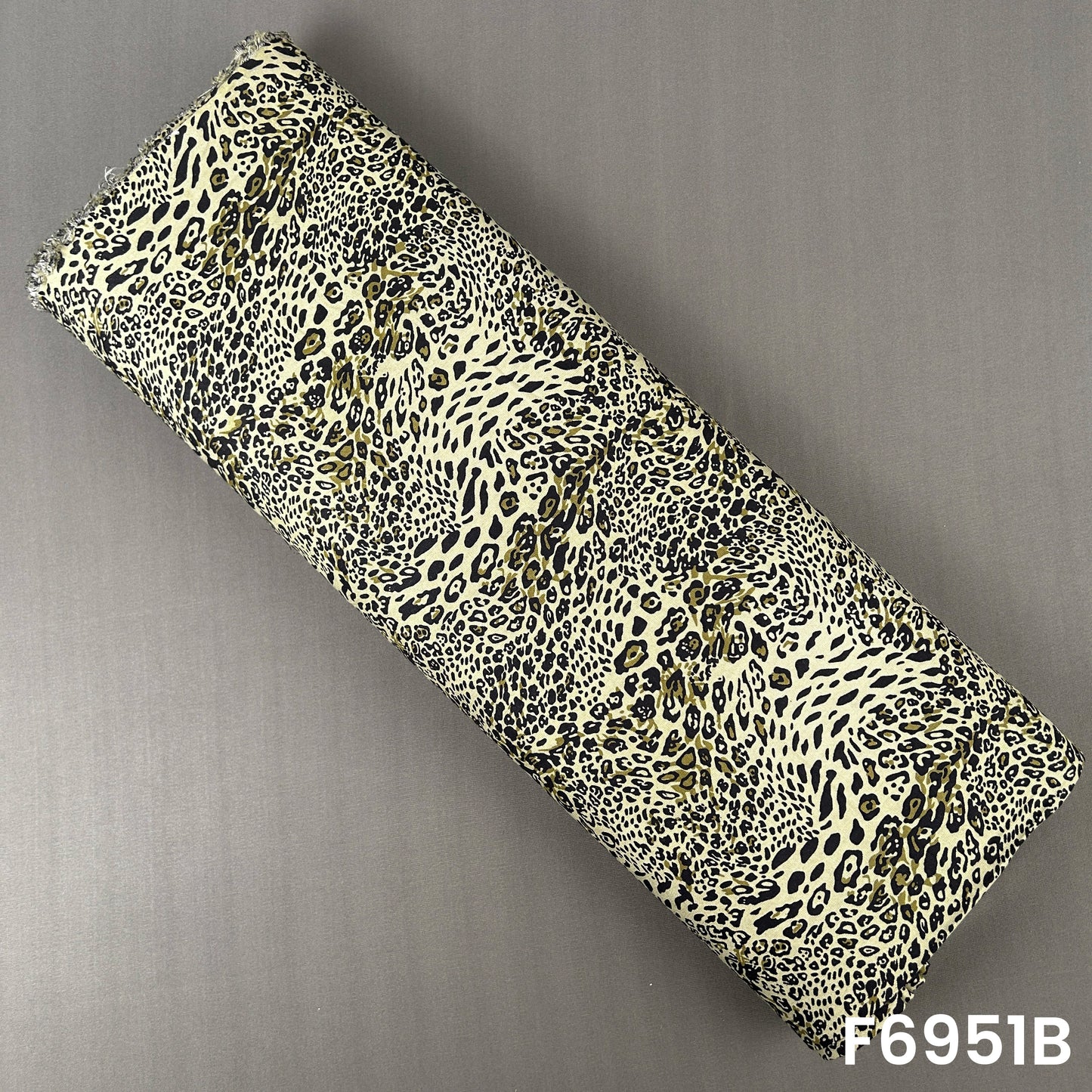 Olive green animal print rayon fabric F6951B designed with striking black and cream leopard motifs