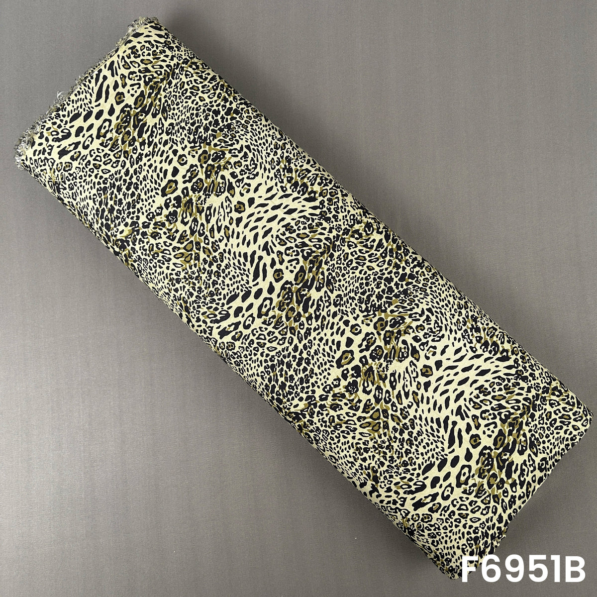 Olive green animal print rayon fabric F6951B designed with striking black and cream leopard motifs