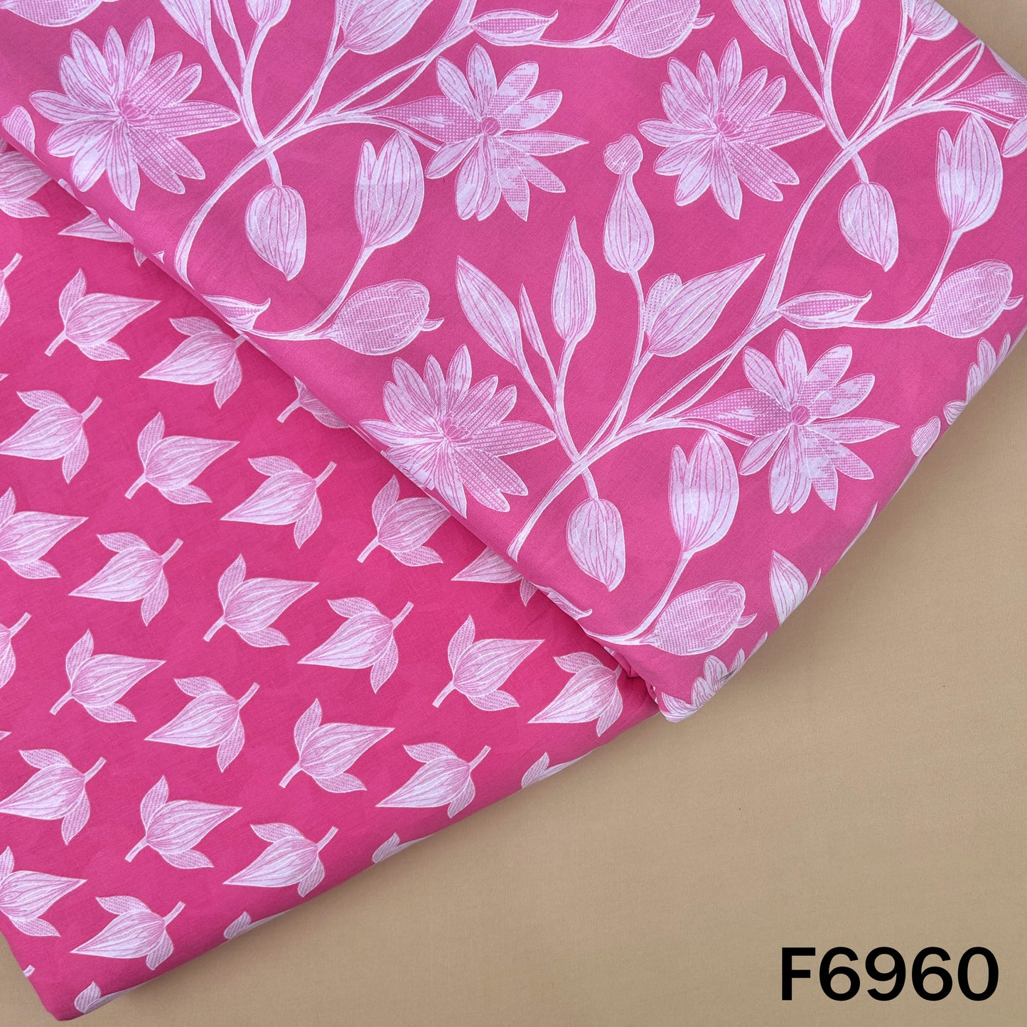 Pink Printed Cotton fabric F6960 with white floral and leaf artwork paired with a smaller coordinated motif pattern