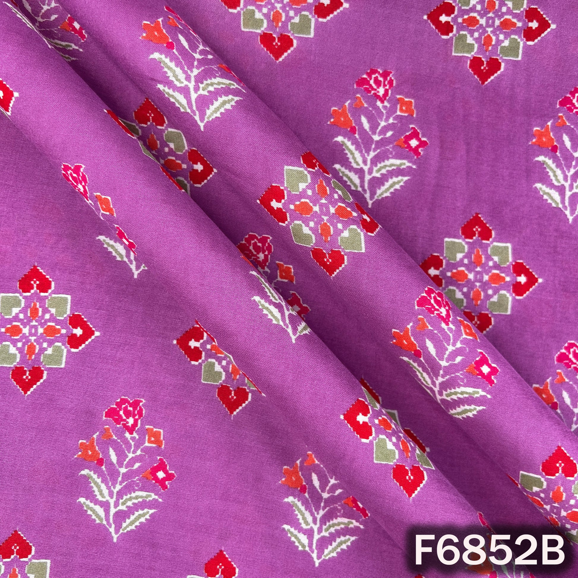 Purple fabric with red and green floral patterns, labeled F6852B.