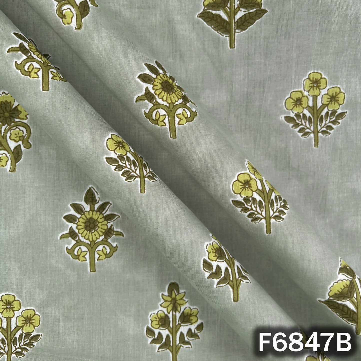 Close-up folds and texture of sage green premium cotton fabric with floral design F6847B