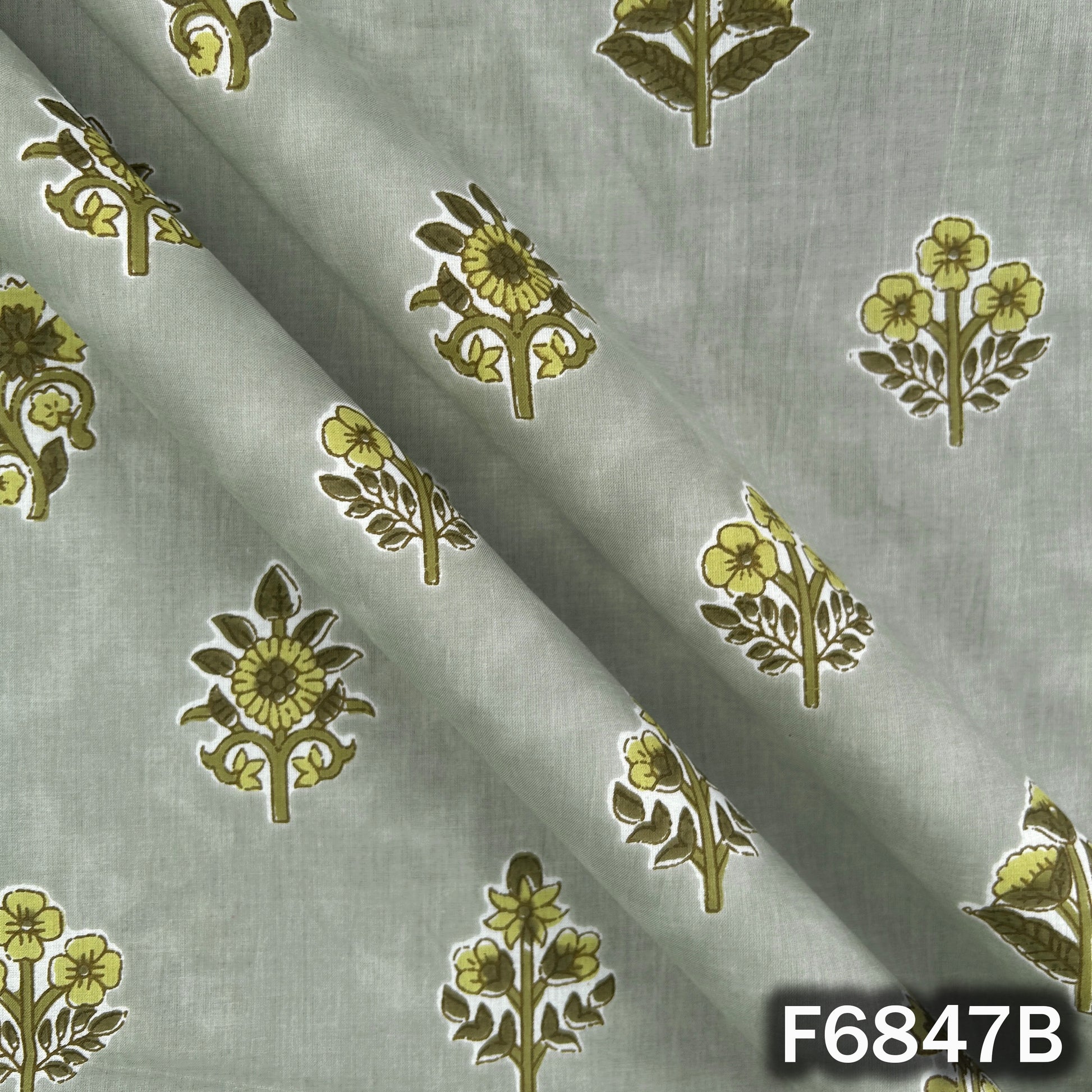 Close-up folds and texture of sage green premium cotton fabric with floral design F6847B